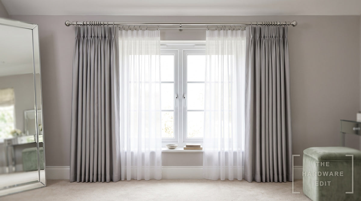 Chrome double curtain pole carrying a voile and curtains