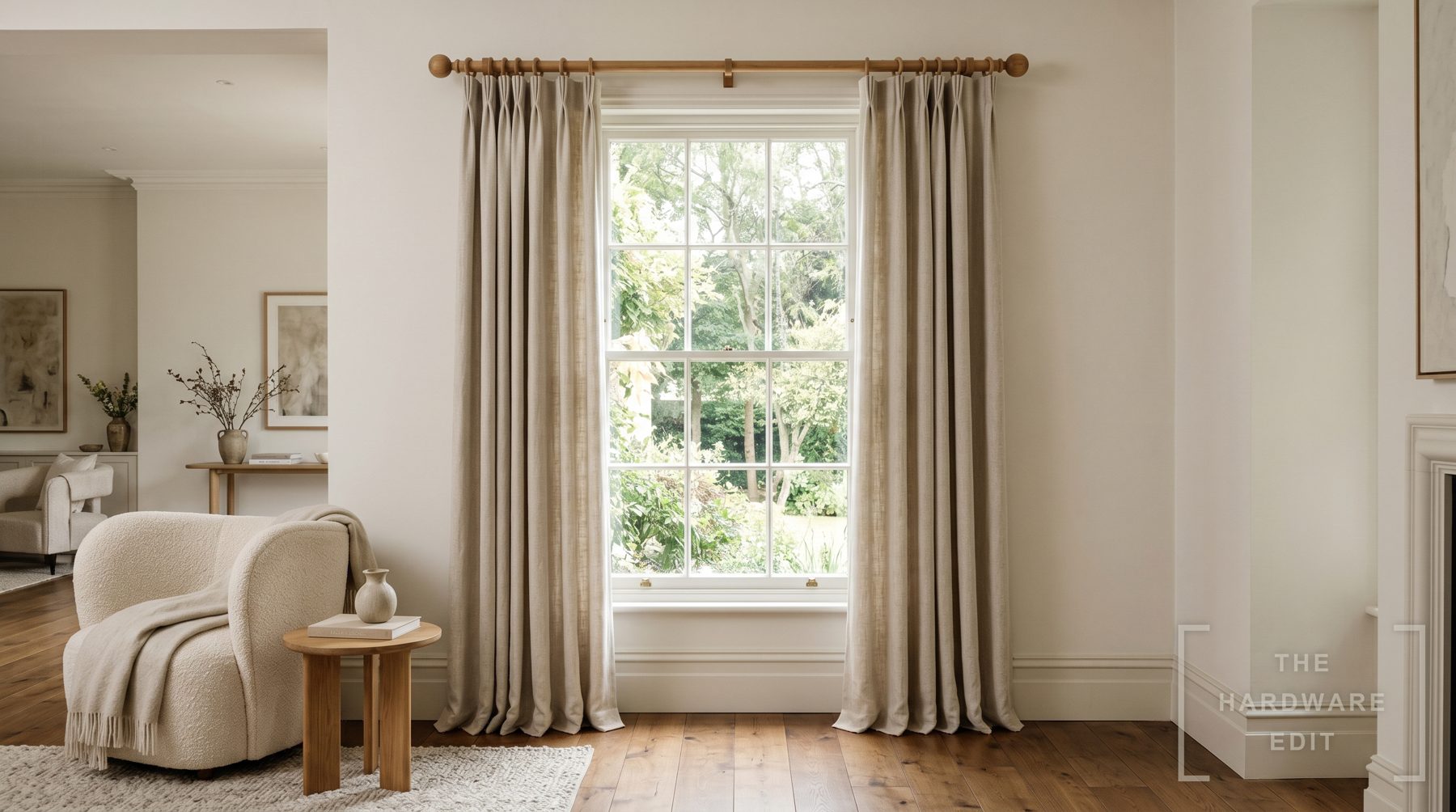 A window dressed with a wooden curtain pole and floor-length curtains